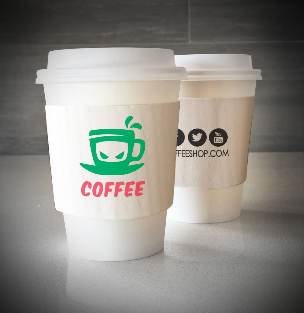 Printed coffee cup sleeves printed on white sleeves with two colors on front and one color on back placed on 2 white paper cups placed on countertop
