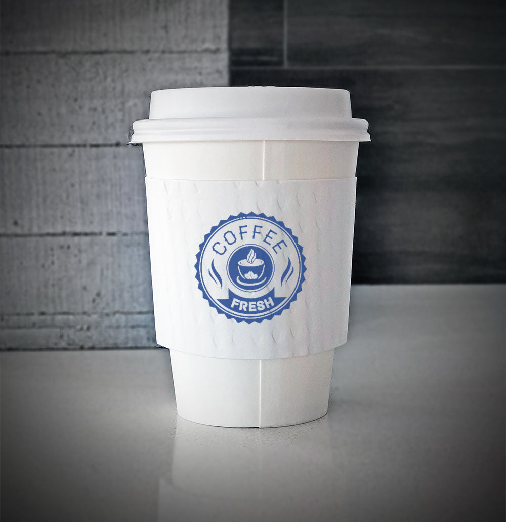 White Printed coffee cup sleeves printed on front with one color and is wrapped around a white paper cup sitting on a countertop