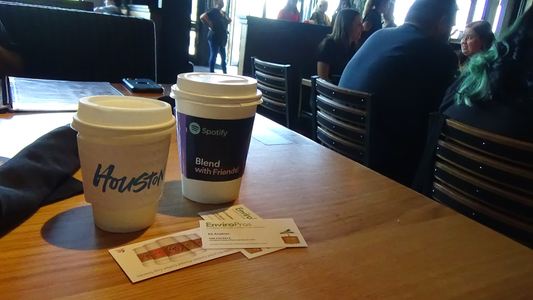 Two different printed cup sleeves on a table of a coffee shop demonstrating the exposure possibility