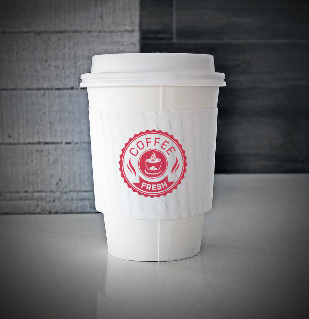White printed coffee cup sleeves printed on front with one color is wrapped on white paper cup sitting on a counter