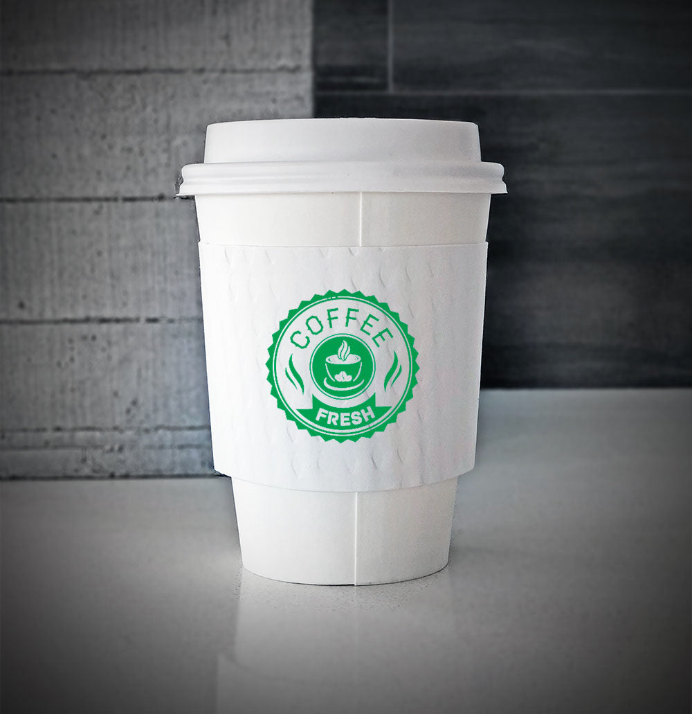 White printed coffee cup sleeves printed on front with one color is wrapped on a white paper cup sitting on a countertop
