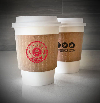 Printed coffee cup sleeve printed on kraft sleeves with one color on front and one color on back placed on 2 white paper cups and are placed on a countertop