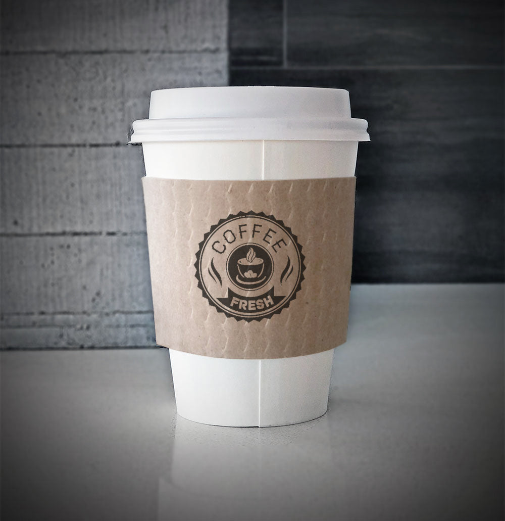 Printed coffee cup sleeves printed on kraft sleeves with one color on front placed on a white paper cup sitting on a countertop