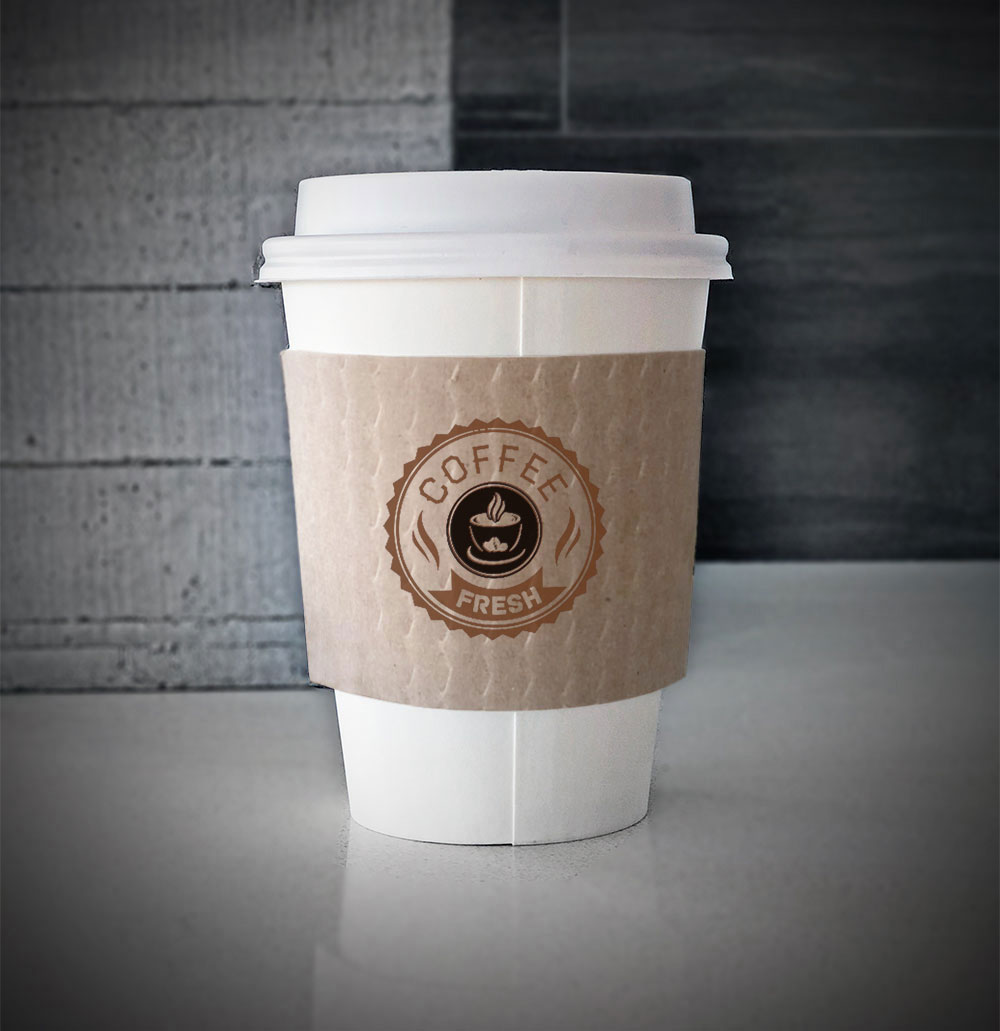 Custom coffee cup sleeves printed on kraft sleeves with two colors on front placed on a white paper cup on a countertop