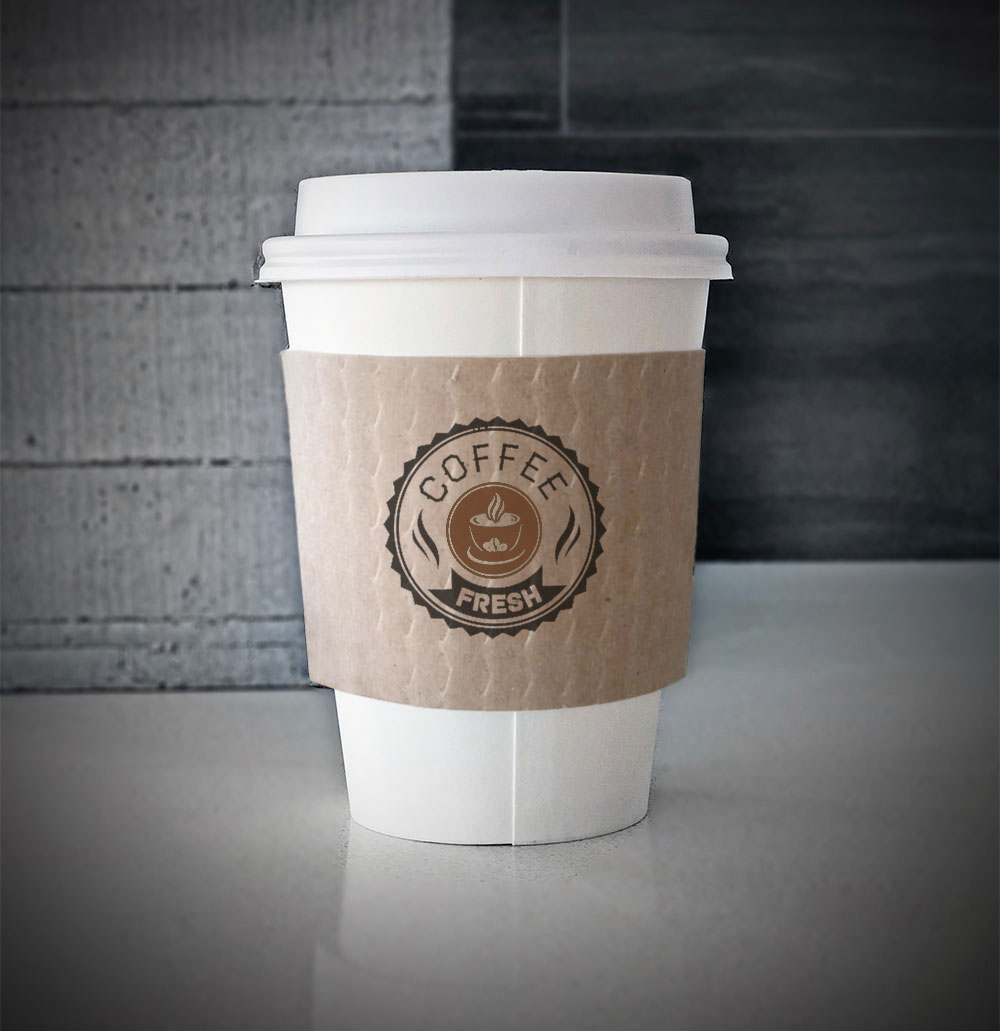 Custom coffee cup sleeves printed on kraft sleeves with two colors on front placed on a white paper cup on a countertop.