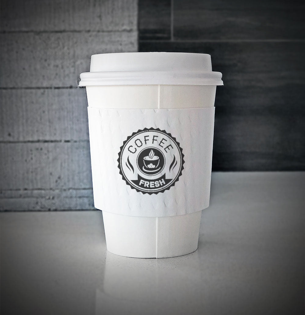 Printed coffee cup sleeves printed on white sleeves with one color on front placed on a white paper cup sitting on a countertop