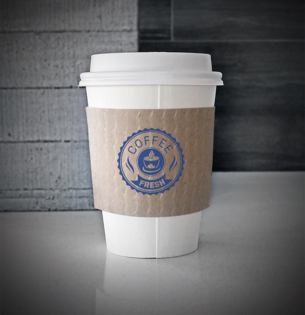 Kraft Printed coffee cup sleeves with one color on front wrapped on a white paper cup sitting on a countertop 