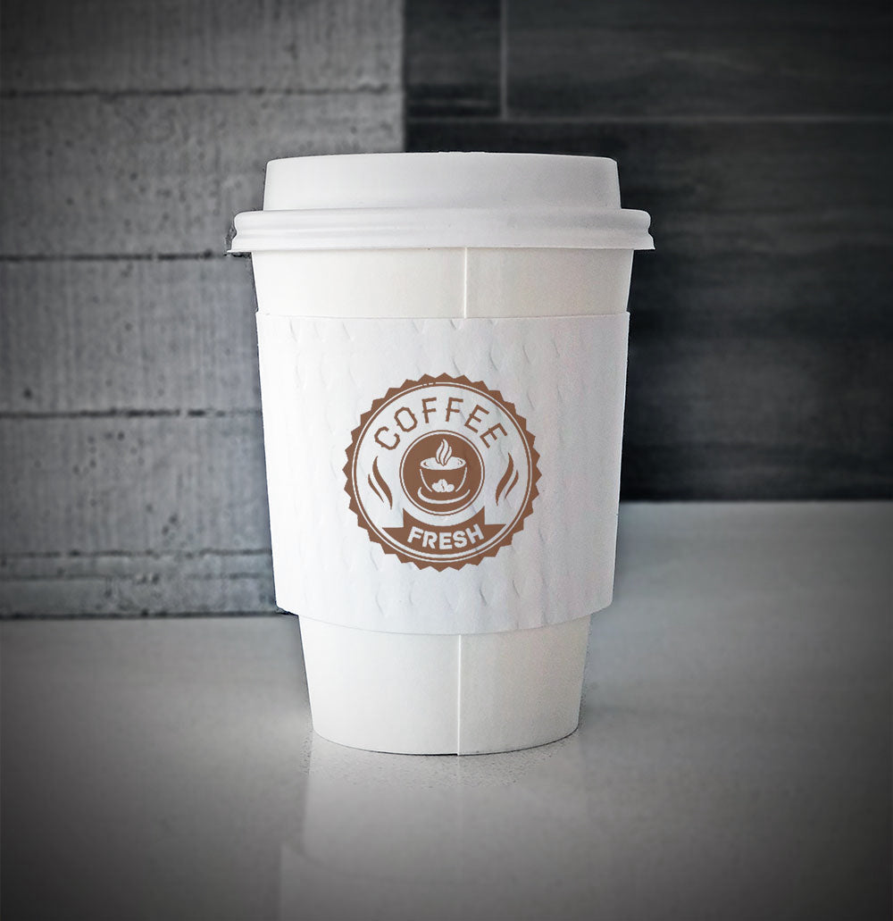 White printed coffee cup sleeves printed on white sleeves with one color on front is wrapped on a white paper cup sitting on a countertop