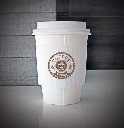 White printed coffee cup sleeves printed on white sleeves with one color on front is wrapped on a white paper cup sitting on a countertop